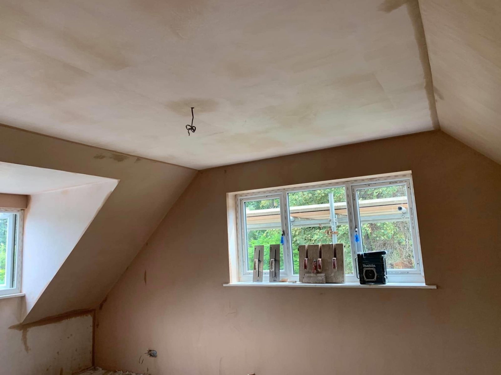 Freshly plastered room with a brick fireplace